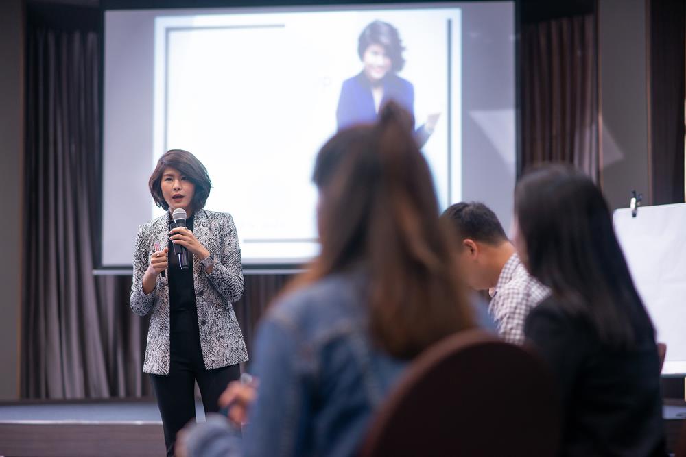 Woman with a microphone in front of an audience